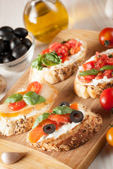 Italian tomato and cheese bruschetta. Tapas, antipasti with chopped vegetables, herbs and oil on grilled ciabatta and baguette bread.