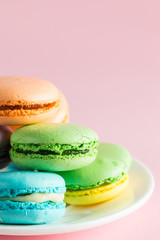 Still life and food photo of cake macarons in a gift box with flowers, a cup of tea on light background. Sweets and desserts concept of macaroons.