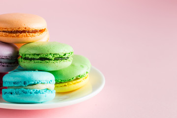 Still life and food photo of cake macarons in a gift box with flowers, a cup of tea on light background. Sweets and desserts concept of macaroons.