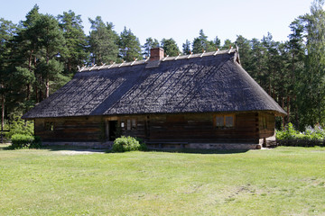 Traditional old wooden house with reed roof in Latvia