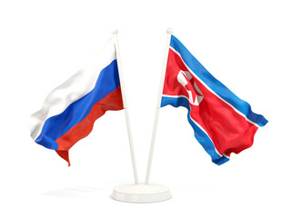 Two waving flags of Russia and North Korea
