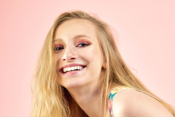 Fototapeta premium Happy cheerful young woman wearing her red hair in bun rejoicing at positive news or birthday gift, looking at camera with joyful and charming smile. Ginger student girl relaxing indoors after college