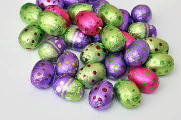 Chocolate Easter eggs in colorful foil isolated on white background.