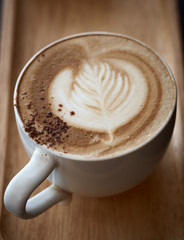 Cappuchino coffee cup at the wooden table