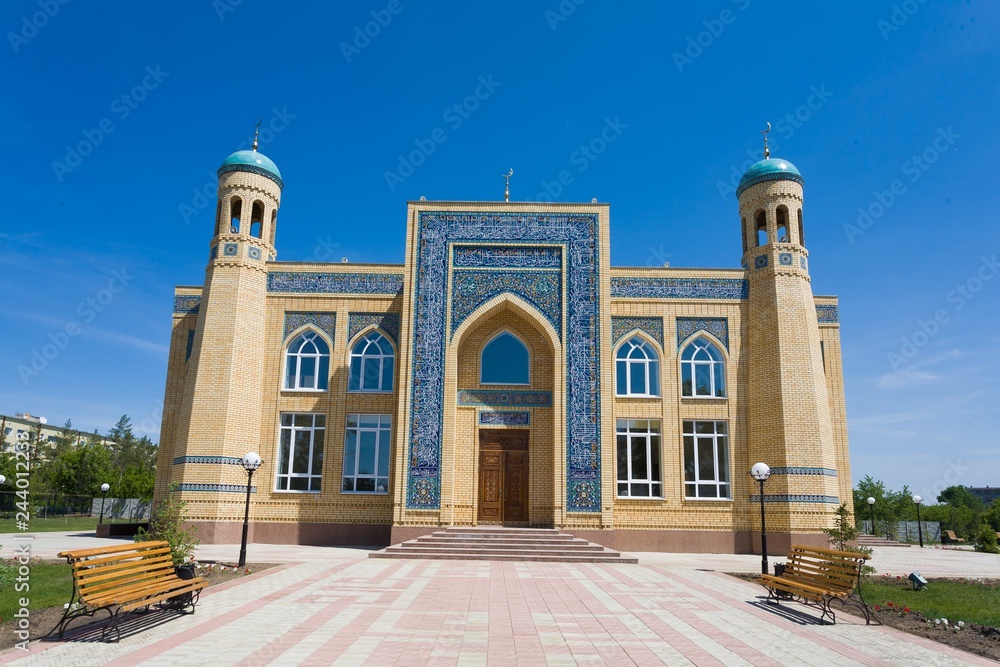 Wall mural Beautiful muslim mosque on a sunny day against blue sky.