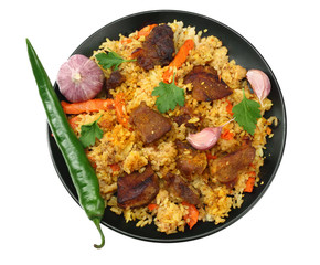 pilaf with meat and chili pepper on black plate isolated on white background. top view