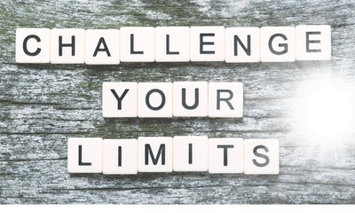Fototapeta na wymiar Challenge your limits sign with wooden cubes on background