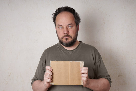  grubby scruffy man holding blank cardboard sign                      
