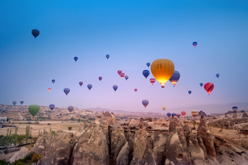 Beautiful hot air balloons flying over Cappadocia landscape at sunrise