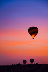 Beautiful hot air balloons flying over Cappadocia landscape at sunrise