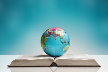 Heavy book and globe on background