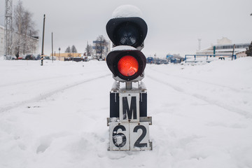 Semaphore on the railway in winter, glowing red