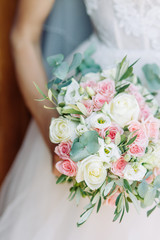 Wedding bouquet and dress details. wedding rings on the table and in the glass.