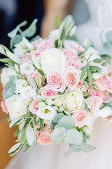 Wedding bouquet and dress details. wedding rings on the table and in the glass.