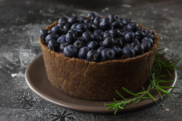 Blueberry vegan cheesecake. Dark photo on black background