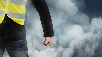 Yellow vests protests. Unrecognizable man clenched his fist in protest. Concept of revolution and...