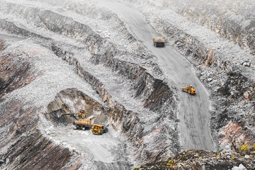 Large mining trucks, excavator and bulldozer in a quarry. Iron ore extraction. Heavy mining...