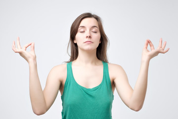 Girl enjoys peaceful atmosphere, keeps hands in mudra sign