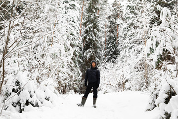 Man in fur winter hat with ear flaps smiling portrait. Extreme in the forest