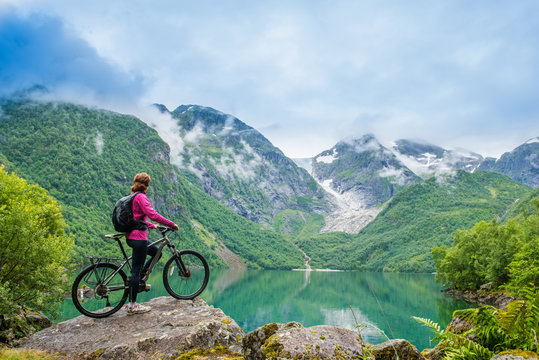Biking woman in Norway against picturesque landscape © Kotangens