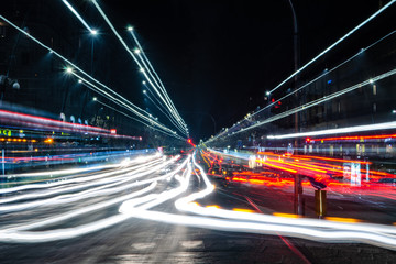 Fototapeta na wymiar Scie colorate luminose lasciate di notte dal traffico su una via della città
