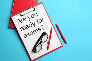 Clipboard with text ARE YOU READY FOR EXAMS? on color background