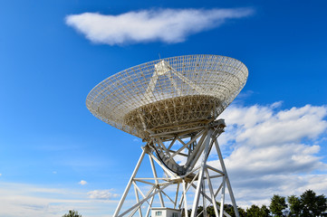 Array of satellite dishes or radio antennas against sky. Space o