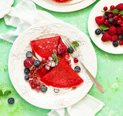 Pancakes are red velvet, with berries and cream. Valentine's Day. Selective focus.