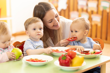 Nursery babies eating healthy food in kindergarten