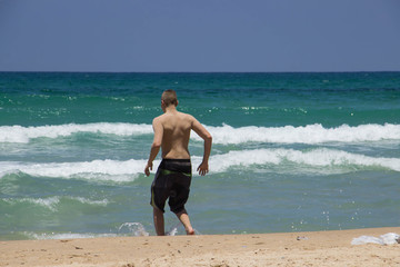 The guy is resting on the beach at the blue sea tender