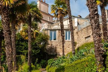 Fototapeta na wymiar Houses and palm trees on the promenade Clair de lune in Dinard