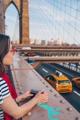 Naklejka premium Young woman with red scarf on Brooklyn Bridge