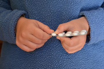 woman taking tablet from a blister pack