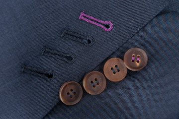 Detalle costura textil, botones chaqueta