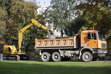  Latvia. Excavator loads trash in a park onto a truck