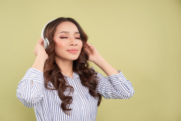 Fototapeta premium Young woman in headphones listening to music from the phone