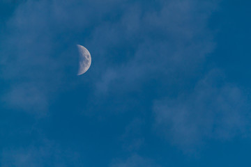 Half waxing Moon in blue sky