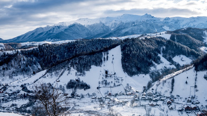 Brasov - Romania, Rucar - Bran snowy picturesque hills on a sunny cold December. Wide panorama of the Carpathian mountains.