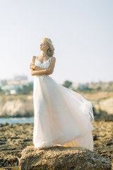 Fototapeta na wymiar Bride on the beach in Cyprus. Sunset photo shoot of a beautiful girl.