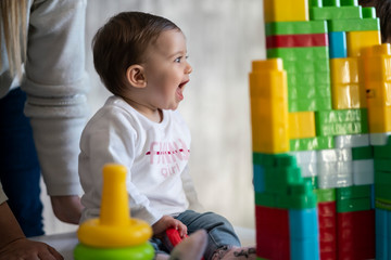 Happy baby playing with toy blocks.