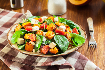 Roasted pumpkin salad with spinach, tomatoes and nuts