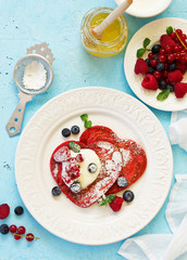 Pancakes red velvet in the form of a heart with berries and cream. Valentine's Day. Selective focus.