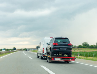 Fototapeta na wymiar Car carrier trailer with new car on highway