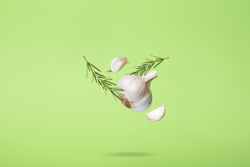 Flying Rosemary and Garlic on Green Background Abstract Food