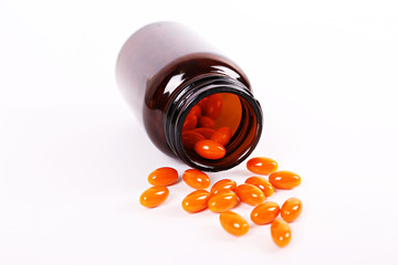 Conceptual image of open ontainer bottle of vitamin c with scattered orange pills on table. Top view, copy space, close up, background.