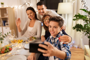 celebration, holidays and people concept - happy family having dinner party at home and taking selfie by smartphone