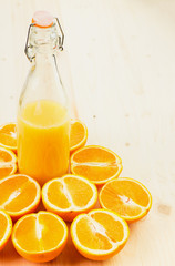 Bottle of freshly pressed orange juice with sliced orange halfs