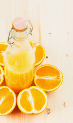 Bottle of freshly pressed orange juice with sliced orange halfs