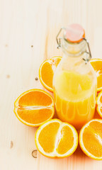 Bottle of freshly pressed orange juice with sliced orange halfs