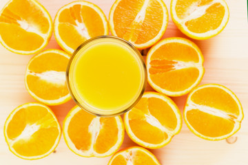 Glass of freshly pressed orange juice with sliced orange halfs